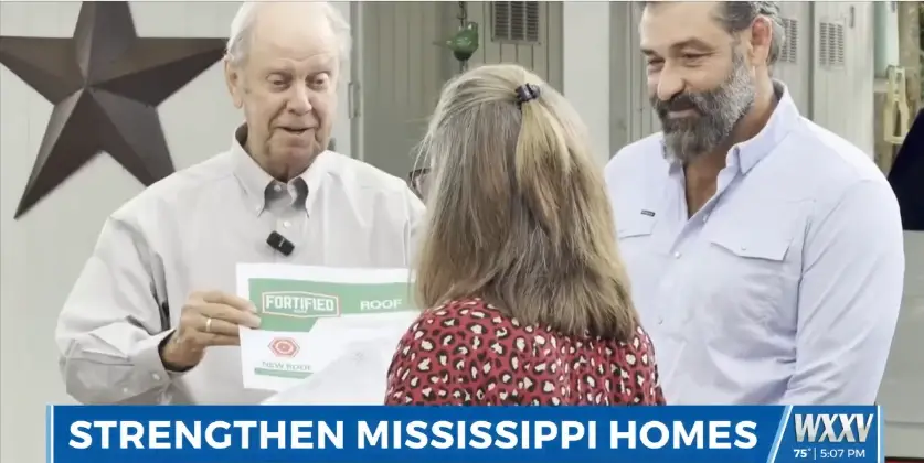 Jason Nezat of Ensured Roofing with a homeowner receiving a FORTIFIED Roof certificate from Mississippi Insurance Commissioner Mike Chaney